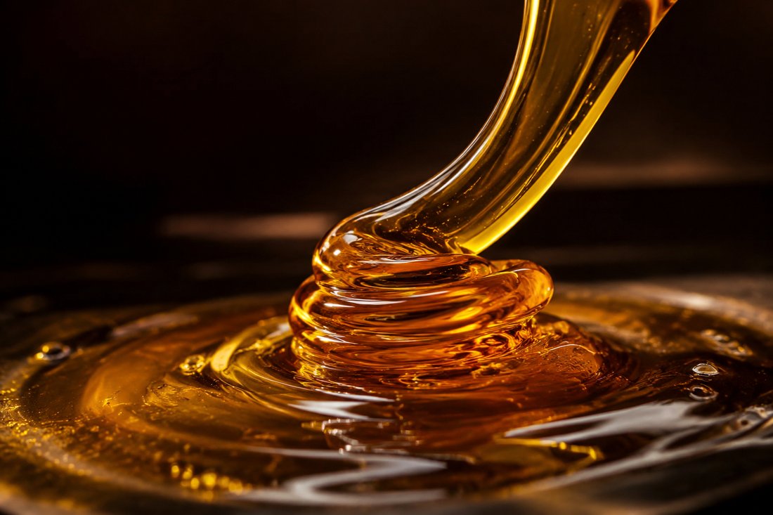 Close-up of golden engine oil showing its viscosity
